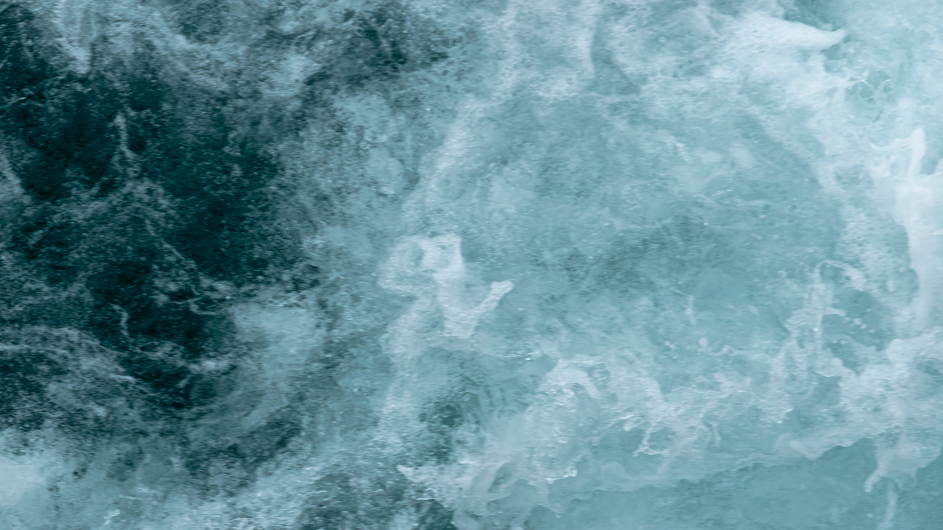 A swirl of blue and white shows ocean waves roiling in the water