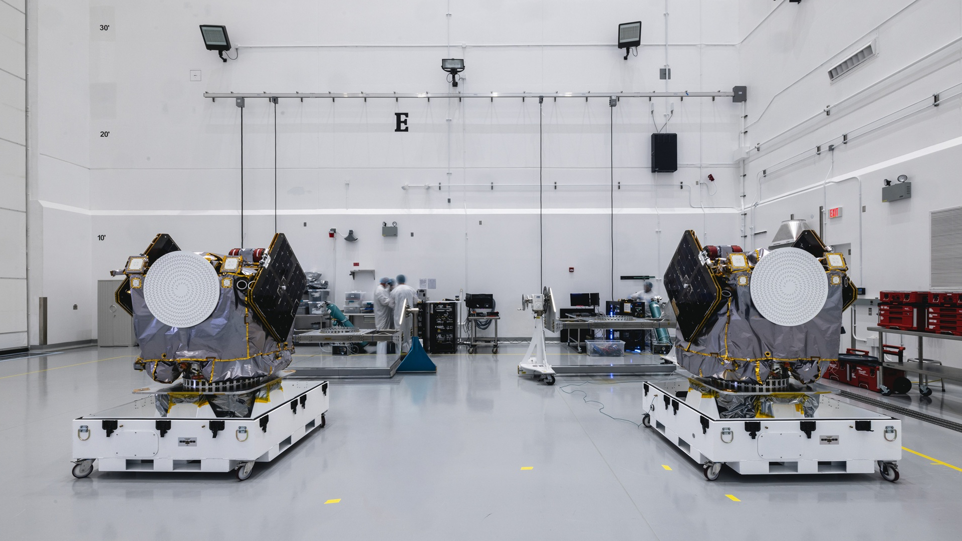 Two engines sit on white platforms in a clean warehouse